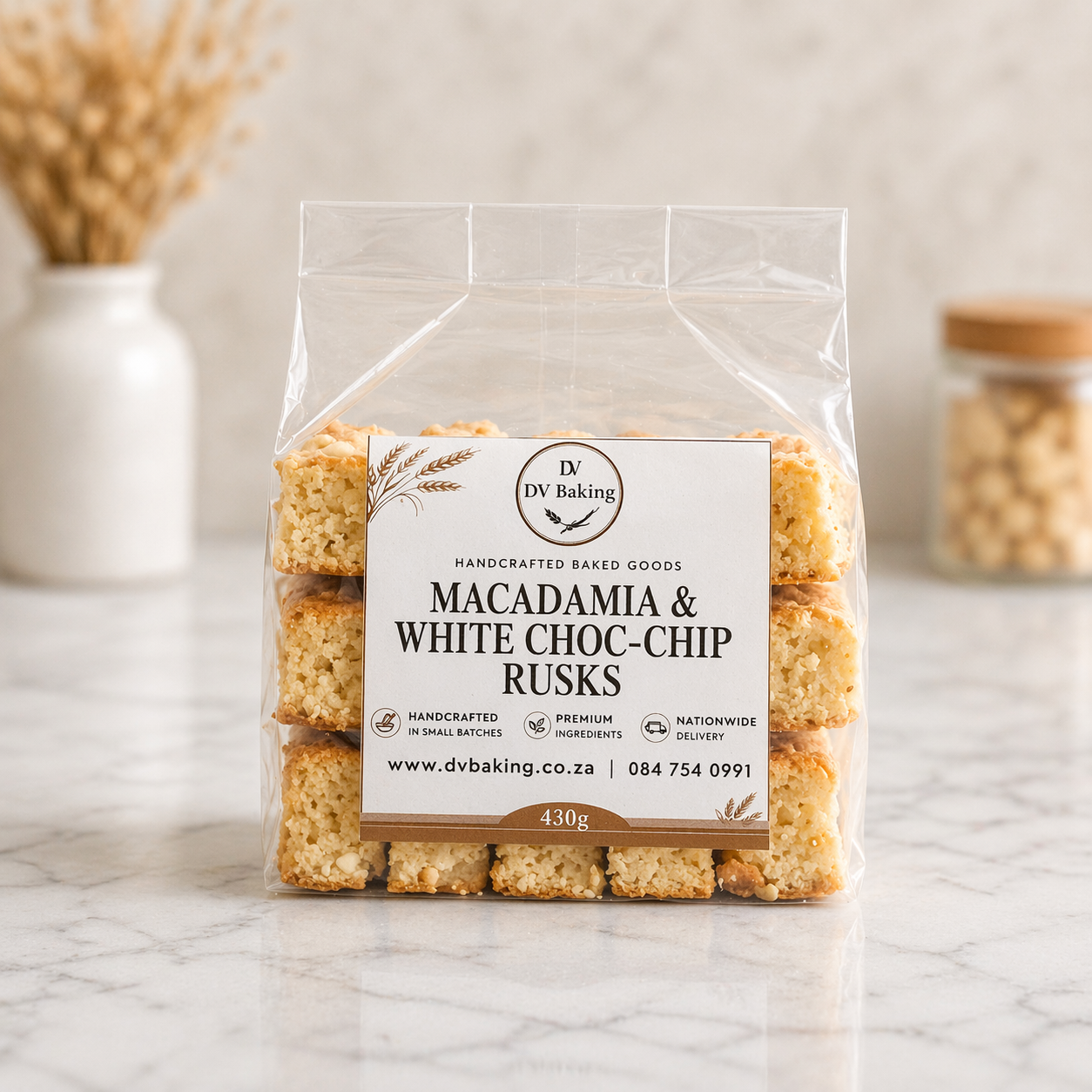 Packaged macadamia and white choc-chip rusks with a clear label on a marble surface.